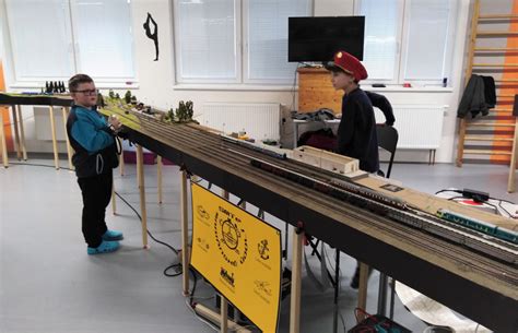 Ilustrácia žiakov v škole s modelovou železnicou